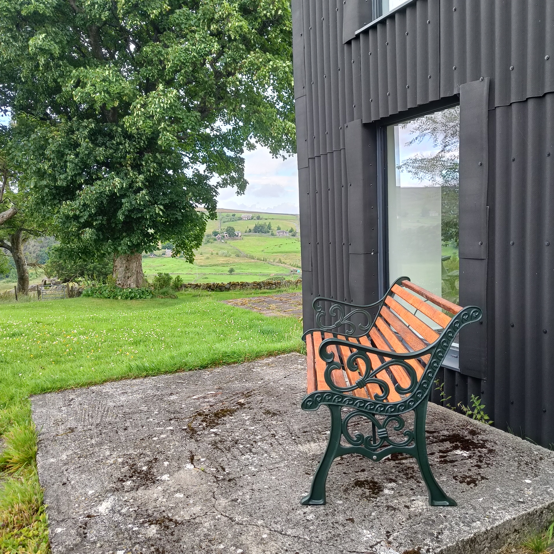 Refurbished outdoor bench. Cast metal bench ends are painted in Little Greene Obsidian Green. New iroko wooden slats have been fitted.